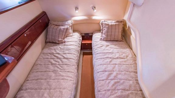 The guest cabin of the motor yacht Hadron with twin beds offers comfortable sleep.